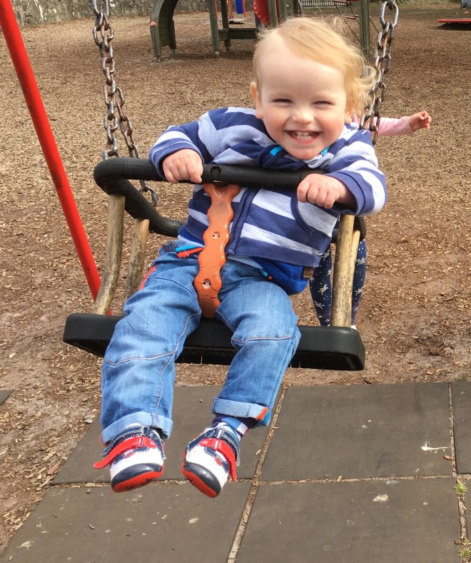 Quinns smiling on a swing