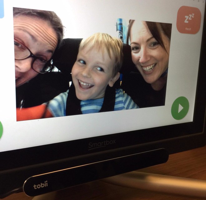Photo of Quinns' eye gaze computer showing him taking a selfie with two others