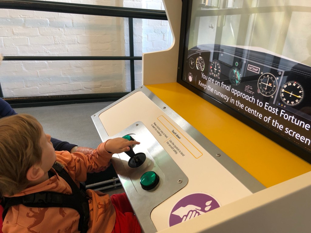 Quinns handles the stick controller of a flight simulator.