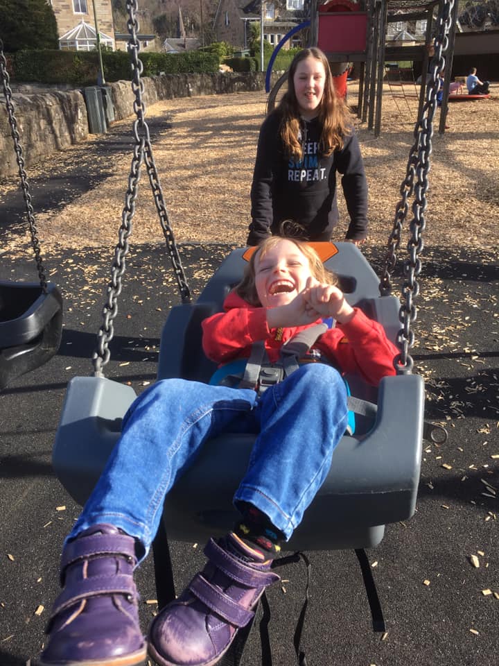 Quinns beams as his Big Sister pushes him on a high backed swing in our local play park.