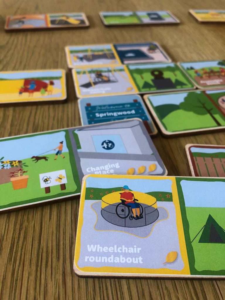 Dominos laid out on a table with wheelchair roundabout and Changing Place Toilet in the foreground.