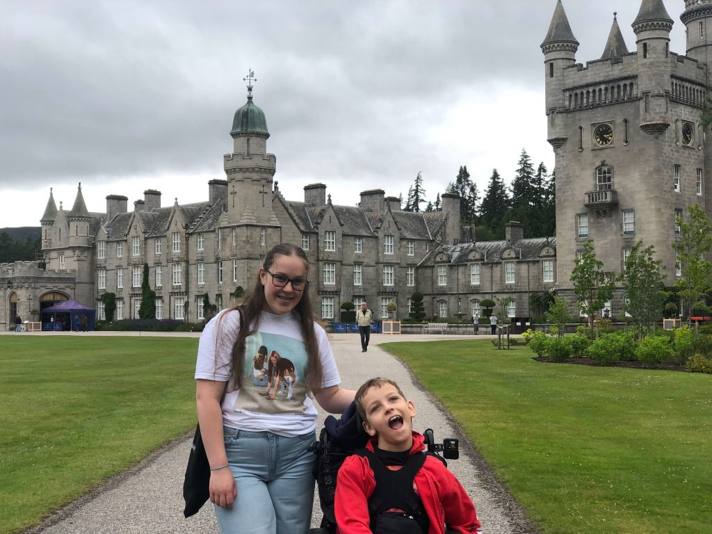 Quinns and Anita smiling in front of Balmoral Castle.