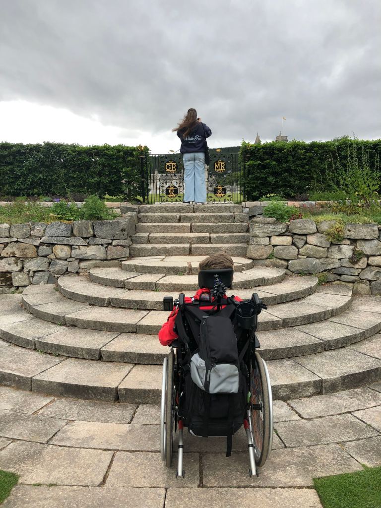 Anita in the background taking a photo of Balmoral from the top of a set of steps. Quinns is in the foreground unable to get up the steps.